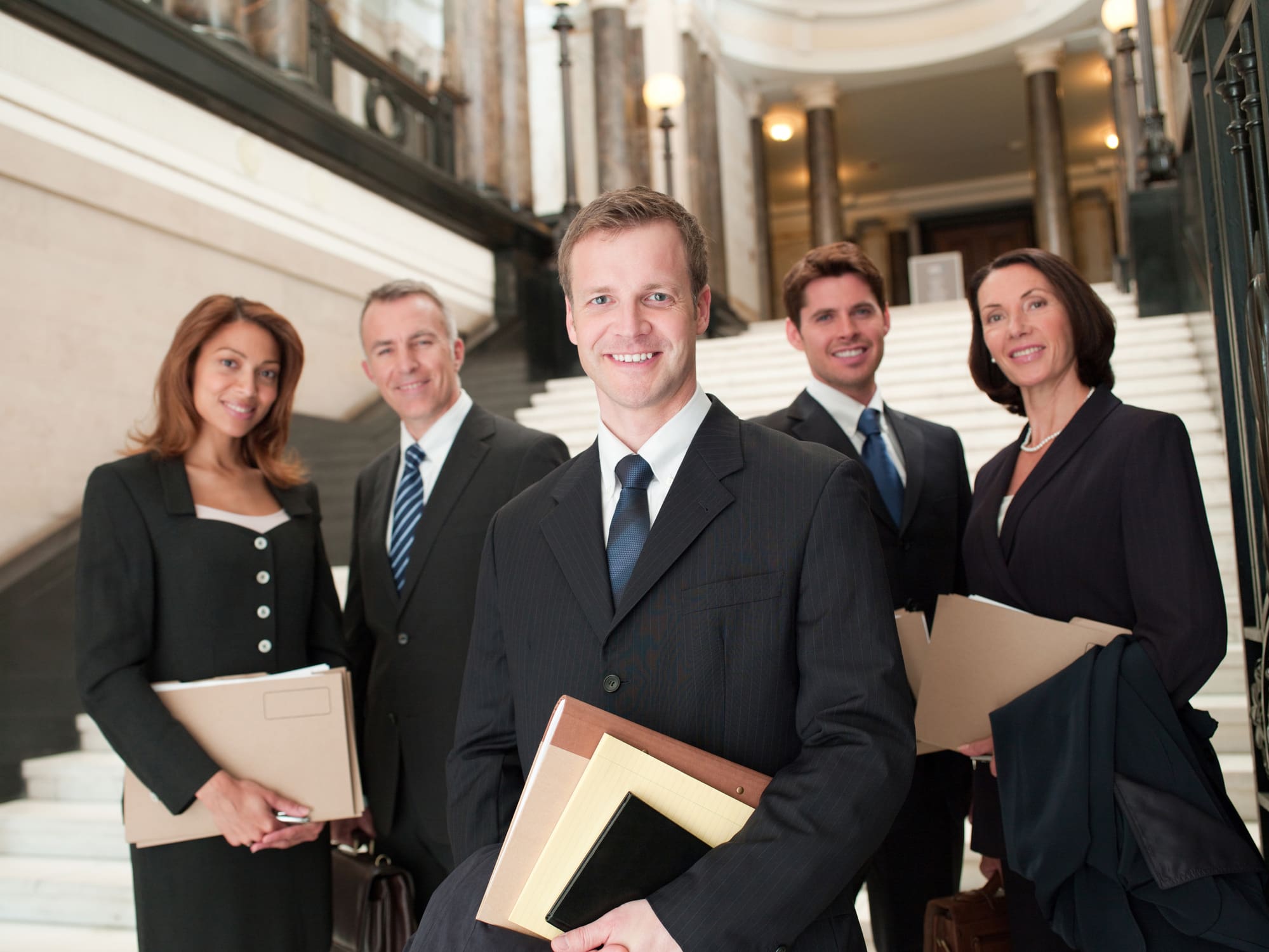 Smiling lawyers with files in lobby
